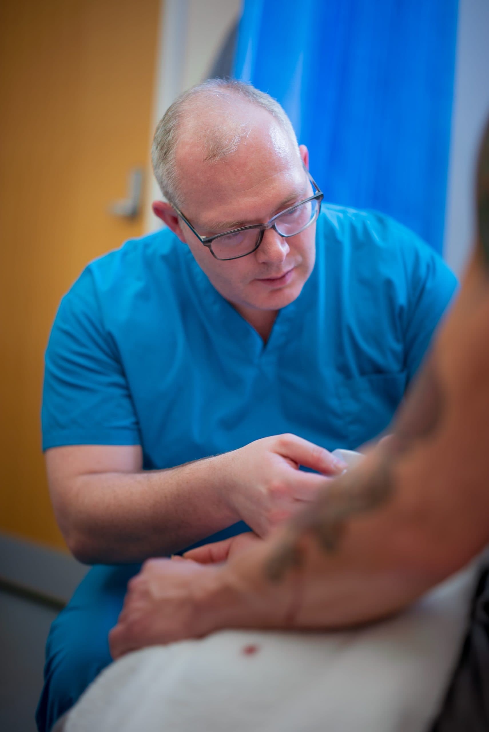 Specialist examining joint for ligament instability